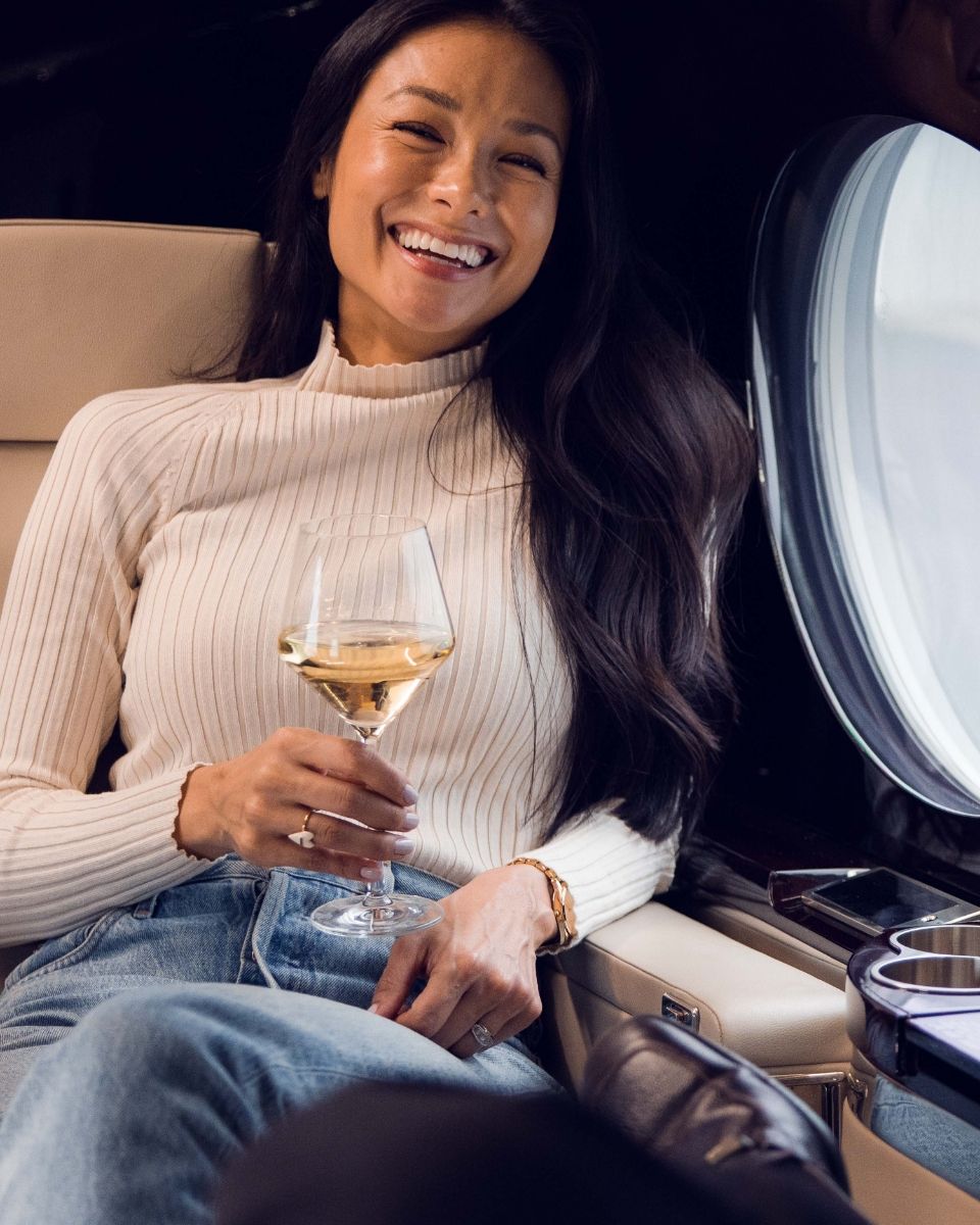 a person on a plane drinking champagne